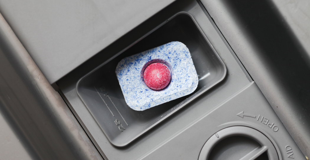 photo of dishwasher detergent pod sitting in the soap dispenser of a dishwasher